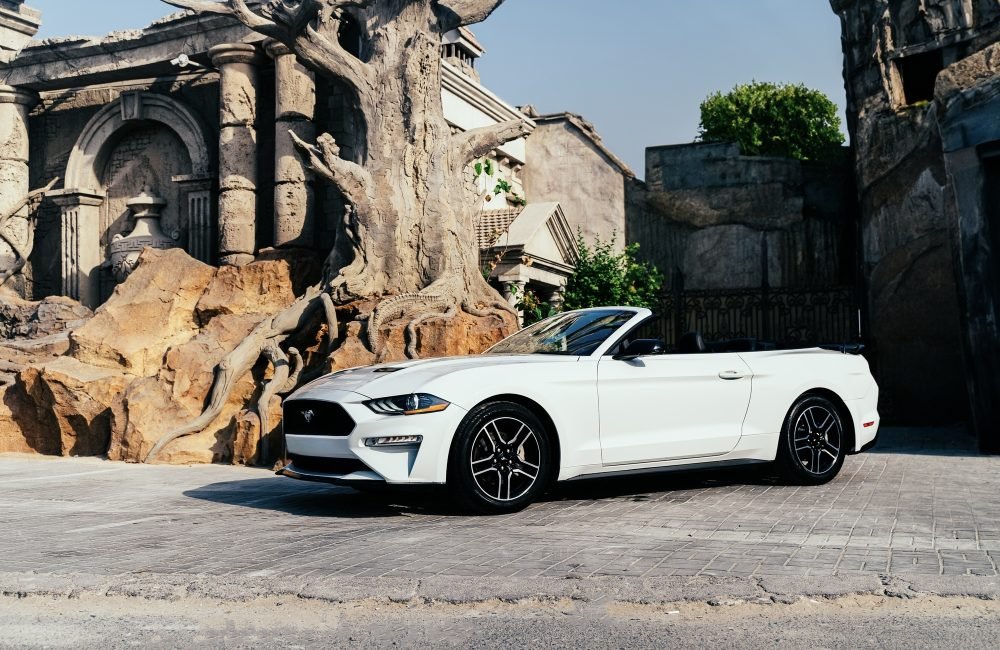 Stylish white Ford Mustang Convertible for rent in Dubai offering a thrilling open-top driving experience with powerful performance modern features and iconic design