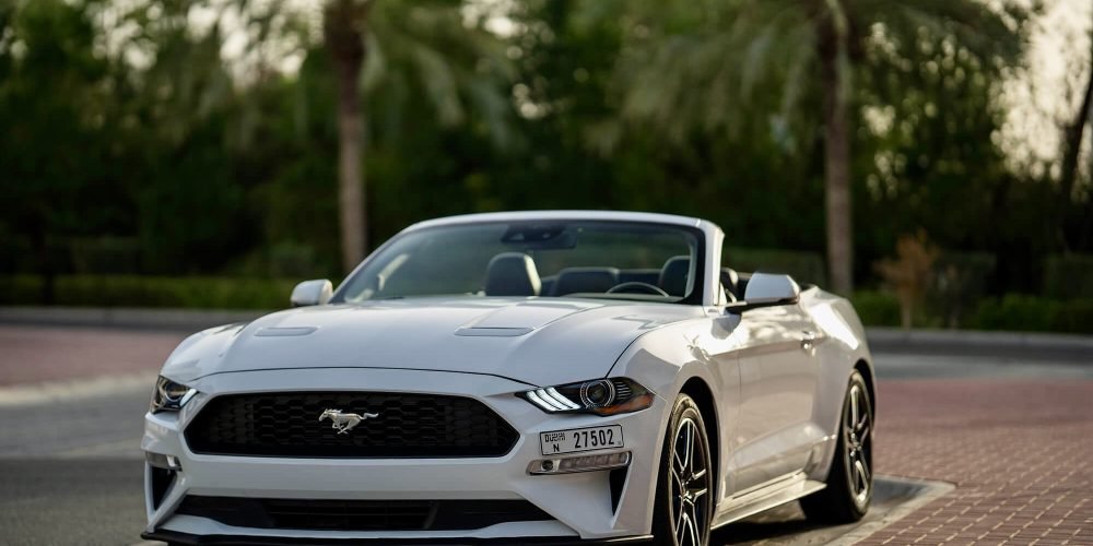Stylish white Ford Mustang Convertible 2024 for rent in Dubai offering a thrilling open-top driving experience with powerful performance modern features and iconic design