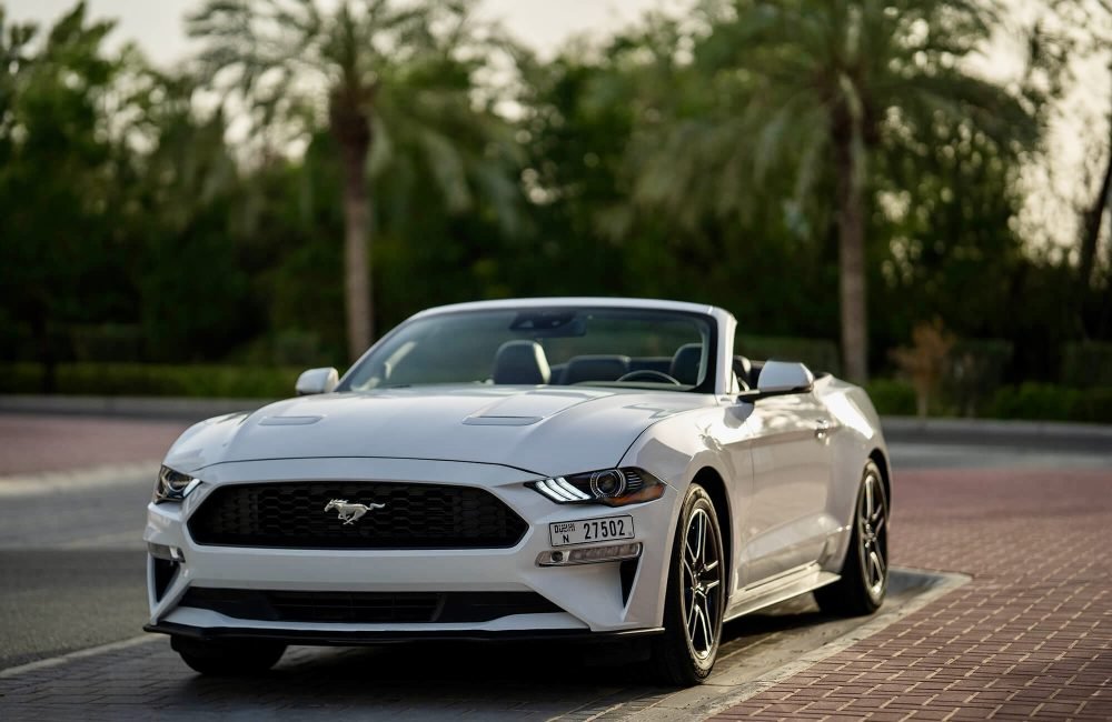 Stylish white Ford Mustang Convertible 2024 for rent in Dubai offering a thrilling open-top driving experience with powerful performance modern features and iconic design