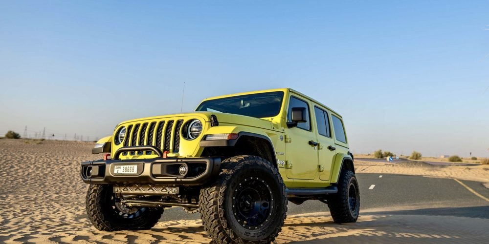 Bold yellow Jeep Wrangler 2023 for rent in Dubai offering rugged off-road capability iconic design and an adventurous open-top driving experience
