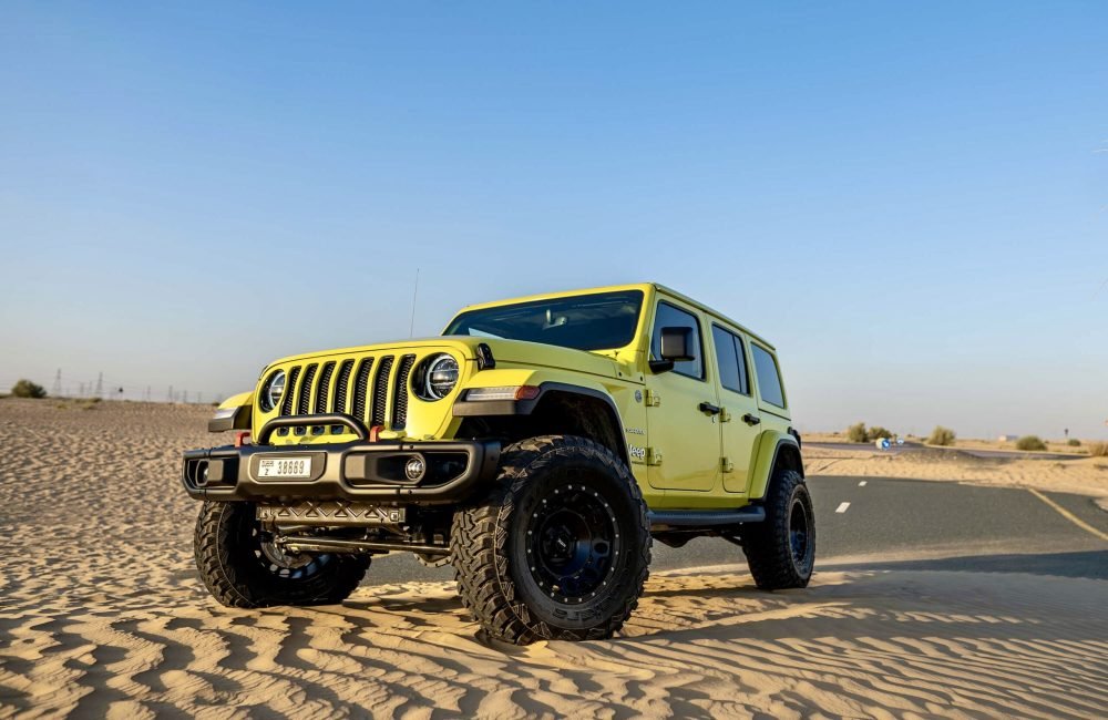 Bold yellow Jeep Wrangler 2023 for rent in Dubai offering rugged off-road capability iconic design and an adventurous open-top driving experience